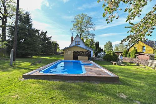 Arnoltice u Decina的住宿－Chaloupka Růženka II，一座带房子的庭院内的游泳池