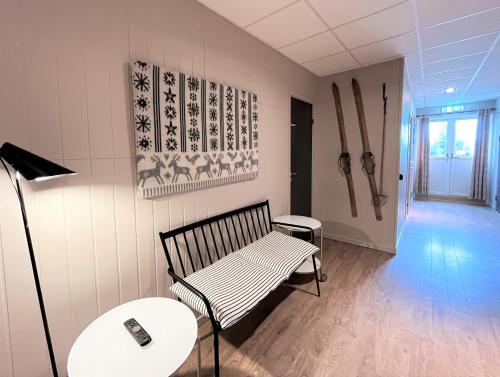 a room with a bench and two tables and a lamp at Vandrarhem Funäsdalen in Funäsdalen