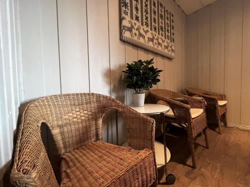 a dining room with a table and wicker chairs at Vandrarhem Funäsdalen in Funäsdalen