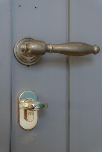 a metal door handle on a white door at RUDINI' CHARMING ROOM in Marzamemi