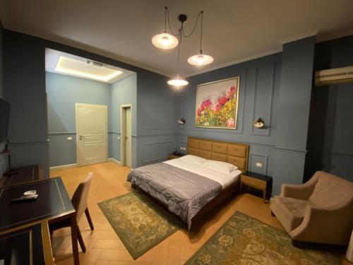 1 dormitorio con 1 cama, 1 mesa y 1 silla en Edisem Hotel, en Tirana