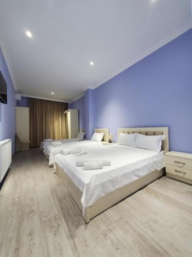 - une chambre avec 3 lits et un mur bleu dans l'établissement Hotel N, à Tskhaltubo
