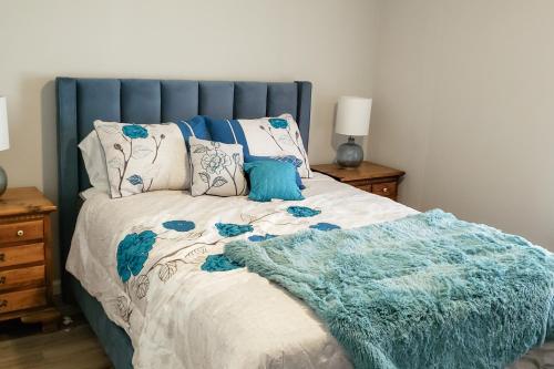 un letto con testiera blu e una coperta sopra di Country Quiet a Sanford