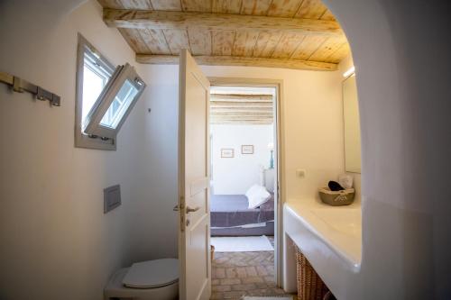 a small bathroom with a toilet and a bedroom at Villa Baroness in Mykonos Town in Mýkonos City