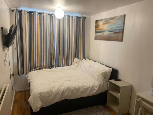 a small bed in a room with a window at Two bedroom flat in London near the 02 in London