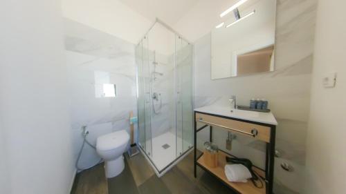 a bathroom with a shower and a toilet and a sink at RUDINI' CHARMING ROOM in Marzamemi