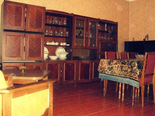 a kitchen with wooden cabinets and a table and chairs at The Kiwi House in Lagodekhi