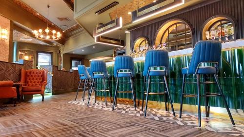 a bar with blue stools in a restaurant at Talbot Hotel Midleton in Midleton
