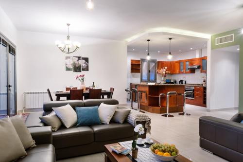 ein Wohnzimmer und eine Küche mit einem Sofa und einem Tisch in der Unterkunft hotelise I Paradise Apartment in Yerevan