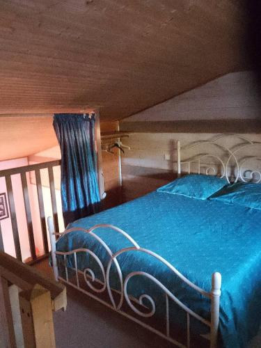 a bedroom with a bed with a blue blanket at Chambre in Pontaubault
