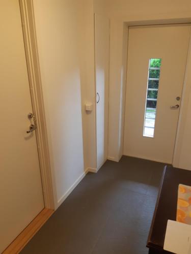 ein leeres Zimmer mit einer Tür und einem Fenster in der Unterkunft Krypinn i Søgne in Kristiansand