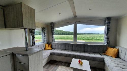 a living room with a couch and a large window at Marduijn in Lomm