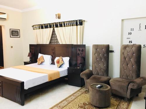 une chambre avec un lit et une chaise dans l'établissement Family lodges, à Islamabad
