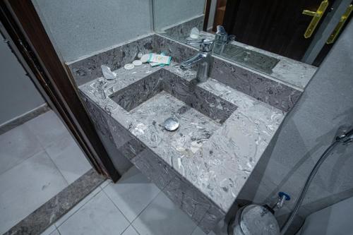 bagno con lavandino in marmo e rubinetto di فندق سرايا المسك Saraya Al Misk Hotel a La Mecca