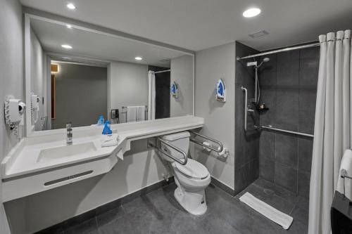 a bathroom with a sink and a toilet and a shower at City Express by Marriott Mérida in Mérida