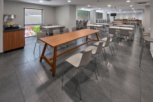 a dining room with a wooden table and chairs at City Express by Marriott Mérida in Mérida