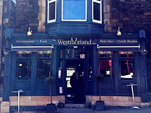 a front view of a restaurant with a blue door at The Westmorland Inn in Bowness-on-Windermere