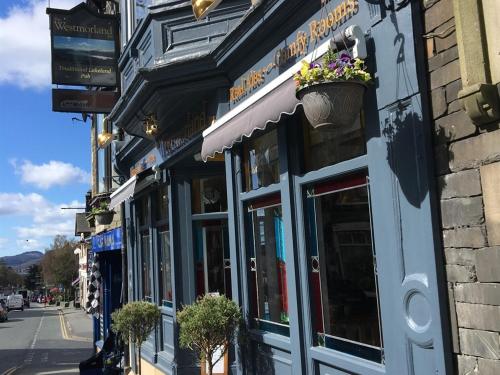 a building with a flower pot on the side of a street at The Westmorland Inn in Bowness-on-Windermere