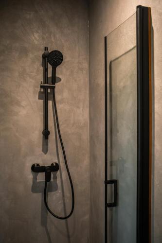 une douche dans une salle de bain avec une pomme de douche dans l'établissement Pépiite Terre de Provence - Lodge nature & spa, à Châteaurenard