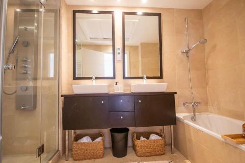 uma casa de banho com 2 lavatórios, um espelho e uma banheira em Casares del Mar D1 9 em Casares