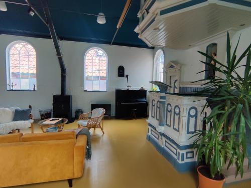 een woonkamer met een bank en een open haard bij Kerkje De Kleine Antonius in Zeerijp