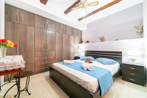 1 dormitorio con 1 cama grande y armarios de madera en Kohili Retreat, en Peroulades