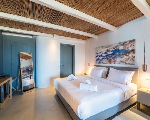 a bedroom with a large white bed with a wooden ceiling at Villa Agavi - Private Pool & Security included - Ideal for events in Mikonos