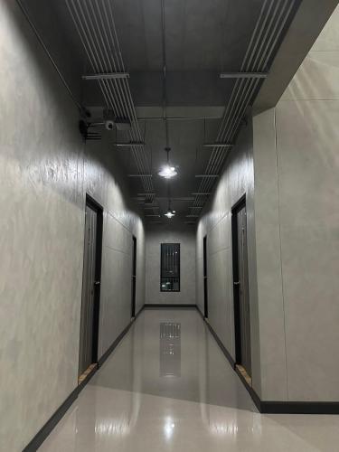 an empty hallway with doors and a hallwayngth at Khampu Resident ก้ามปู เรสซิเด้นท์ in Maha Sarakham