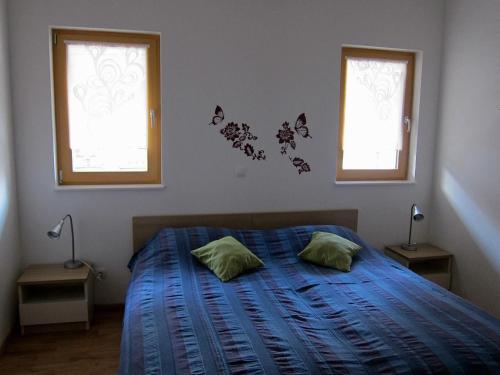 1 dormitorio con 1 cama con mariposas en la pared en Apartment House Cviter en Bovec