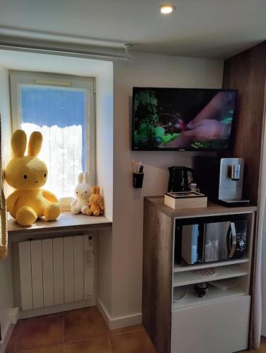 a room with two stuffed animals sitting on a window sill at La maison de Miffy in La Chapelle du Chêne