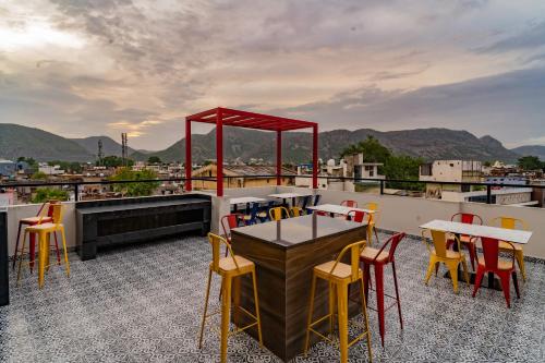 a patio with tables and chairs on a roof at Sparrow Hotels managed by Siara in Alwar