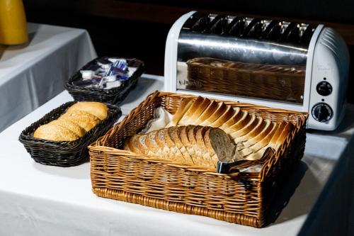 two baskets of bread and a toaster on a table at The Londoner Hotel Sliema in Sliema