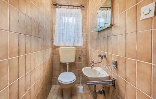 a bathroom with a toilet and a sink at Lovely Apartment In Lopar With House A Panoramic View in Lopar