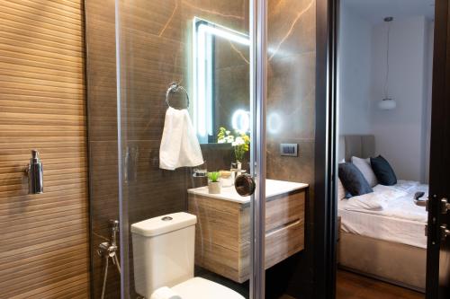 een badkamer met een douche, een toilet en een bed bij hotelise I Shard Apartment in Jerevan