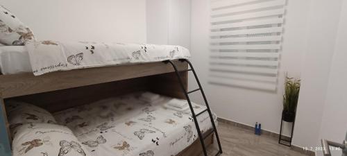 a bunk bed in a room with a white wall at Apartmani Dalmacija Drage in Drage
