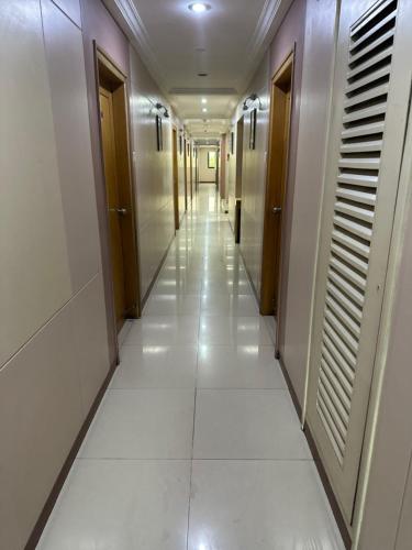 a hallway of elevators in a building with white floors at Hotel Ashirwad in Pune