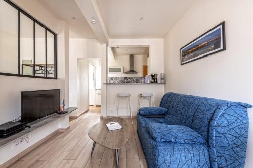 un salon avec un canapé bleu et une table dans l'établissement Studio Christiane - en plein coeur de Roscoff, à Roscoff