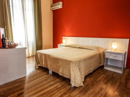 a bedroom with a bed and a red wall at Locanda Scirocco in Castellammare del Golfo