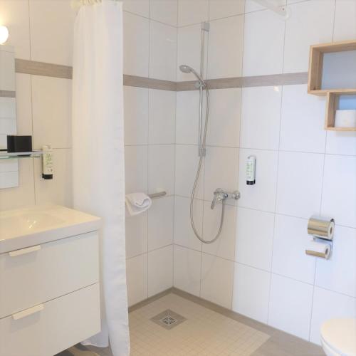 a bathroom with a shower and a sink at Hotel Strand26 an der Ostsee in Ostseebad Nienhagen