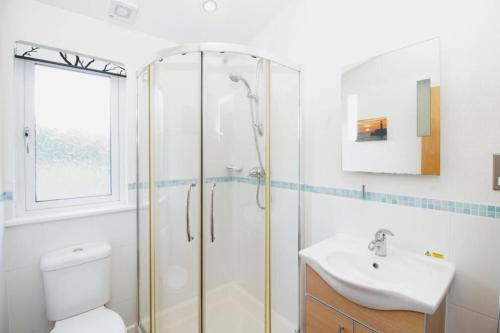 a bathroom with a shower and a toilet and a sink at 10 Trehawks in Wadebridge