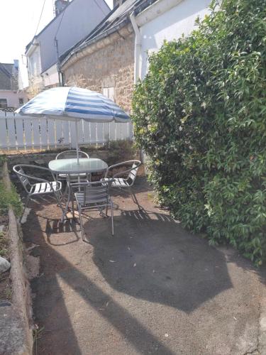 a table and chairs under an umbrella in a yard at Ty Cado in Belz