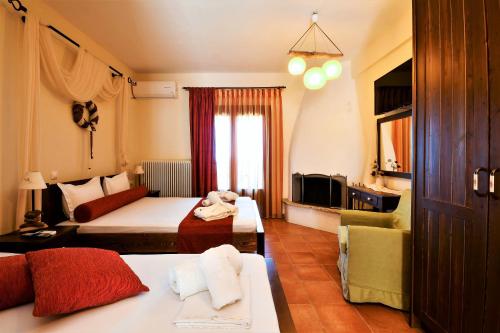 SkítiにあるGuesthouse Amanitis Caesareaのベッド2台とソファが備わるホテルルームです。