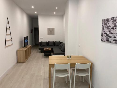 ein Wohnzimmer mit einem Tisch, Stühlen und einem Sofa in der Unterkunft Matadero Apartments 2 in Madrid