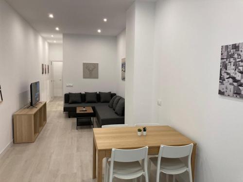 ein Wohnzimmer mit einem Tisch und einem Sofa in der Unterkunft Matadero Apartments 2 in Madrid