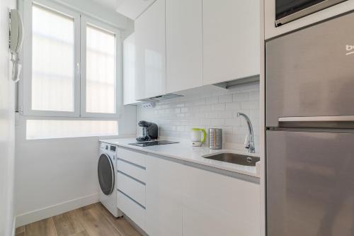 cocina blanca con fregadero y lavavajillas en Arturo Soria Apartments3, en Madrid