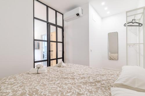 a white bedroom with a large bed and a window at Arturo Soria Apartments3 in Madrid