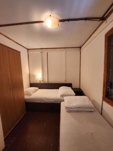 een kleine kamer met 2 bedden en een licht bij Бунгала - Камчия - Електрон Универс in Kamchia