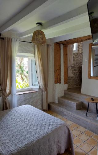 une chambre avec un lit et une fenêtre dans l'établissement Le Logis des Remparts Coeur de la Cité médiévale, Jardin privé, à Carcassonne
