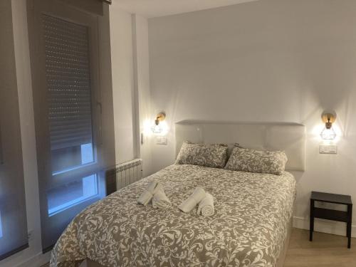 Un dormitorio con una cama con dos zapatos. en Bravo Murillo Apartments, en Madrid