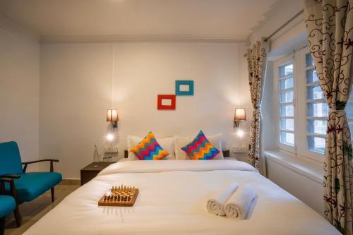 1 dormitorio con 1 cama y 1 silla azul en goSTOPS Srinagar en Srinagar